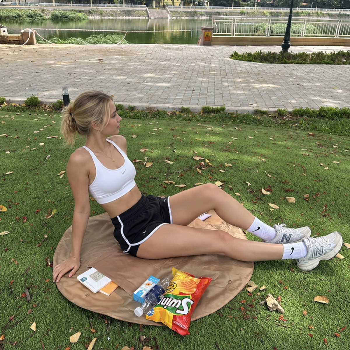 Amiga sentada sobre la bolsa NURNAR marrón desplegada como manta en el parque